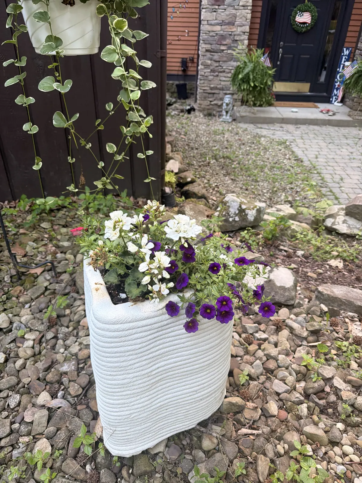 White printed concrete planter with flowers in an outdoor setting